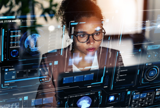 A woman wearing glasses looks at multiple holographic computer screens displaying data, graphs, and digital interfaces in a tech-focused workspace, analyzing trends and threats like SEO poisoning.