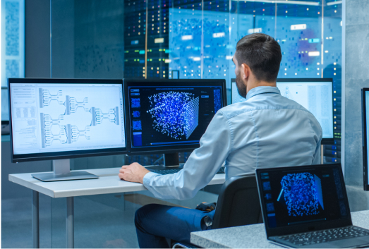 A man sits at a desk with multiple monitors displaying data visualizations, network diagrams, and potential SEO poisoning alerts in a modern control room or data center.